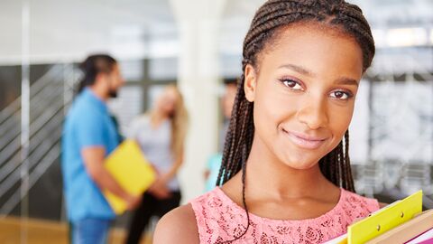 Berufliche Erstausbildung Eine junge Auszubildende mit Unterlagen unterm Arm